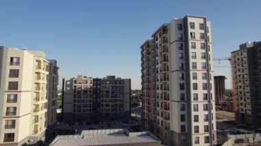 İnsansız hava aracı güneşli yaz gününde apartmanların üzerinden uçuyor.