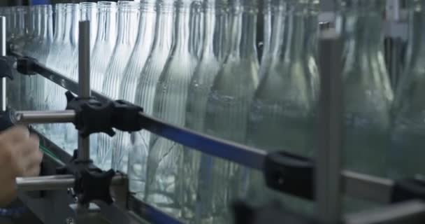 一名工人用她的手检查玻璃瓶在传送机上移动的情况 慢动作 — 图库视频影像