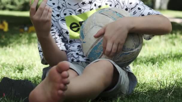 Tonåring Shorts Shirt Och Barfota Sitter Gräset Parken Med Fotboll — Stockvideo