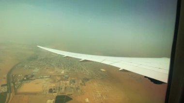 Kanatlarındaki uçağın videosu, altındaki Dubai toprakları ve ufuktaki toz fırtınası. Hava görünümü