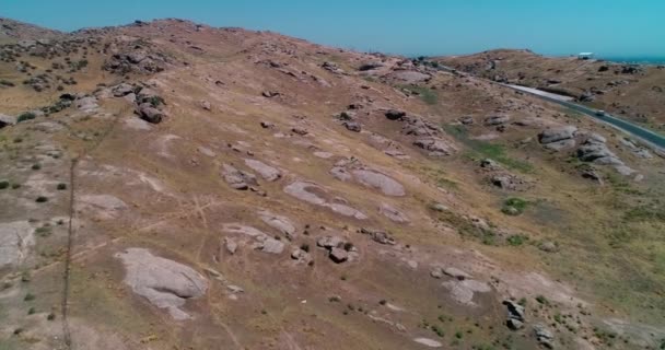 ドローンが丘の間の山道を飛ぶ 空中ビュー スローモーション — ストック動画