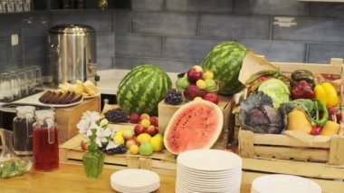 Küçük bir otelde kahvaltı odası. Sosis, et, salata, peynir ve içeceklerle servis edilen masa. Meyveli masa, karpuz, muz. Yavaş Hareket.