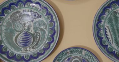Seramikçi ressamın galerisindeki duvarda asılı seramik tabaklar var. Gerçek zamanlı, 4k.