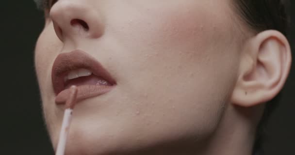 若いエレガントな女性は唇に光沢を当てています 閉じる スローモーション スタジオショット — ストック動画
