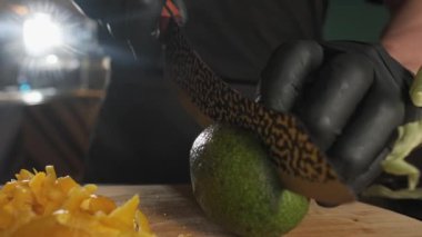 Şef, mutfak bıçağıyla avokado kesiyor. Yavaş Hareket, Kapat.