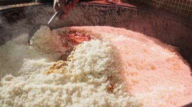 Şef büyük bir pilav kazanında slotlu kaşıkla pilav karıştırır. Yavaş Hareket, Kapat.