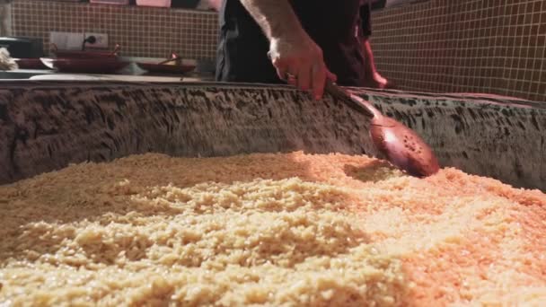 厨师用一个开槽的勺子在一个大的皮面包锅里搅拌米饭 慢动作 — 图库视频影像