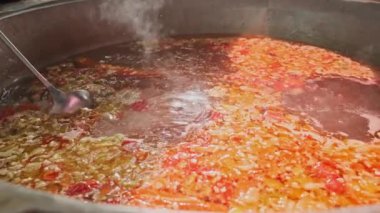 Şef, et çorbasını büyük bir kazanda sebzelerle karıştırıyor. Yavaş Hareket, Kapat.