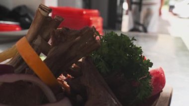 Şef servis edilen et, ot, domates ve sebzelerle servis edilen tabağa limon suyu sıkıyor. Yavaş Hareket, Kapat.