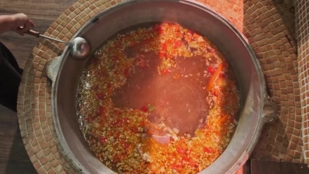 厨师把肉汤和蔬菜混合在一个大大锅里 用一个有槽的勺子 慢动作 — 图库视频影像