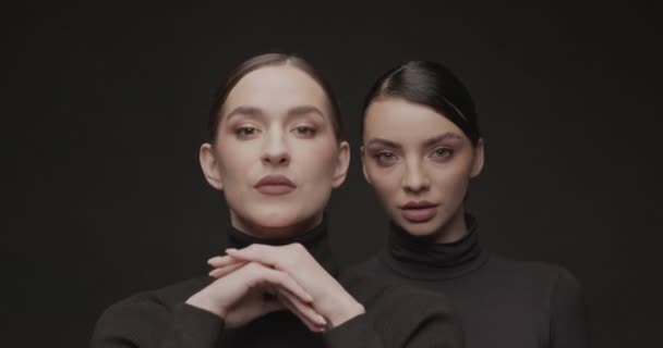 Duas Jovens Mulheres Elegantes Com Boa Maquiagem Fundo Preto Movimento — Vídeo de Stock