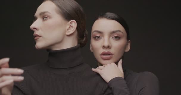 Dos Mujeres Jóvenes Elegantes Con Buen Maquillaje Sobre Fondo Negro — Vídeo de stock