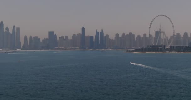 ドローンは海の波を越えて海岸沿いの街へと飛んでいく ドバイ アラブ首長国連邦 空中風景 — ストック動画