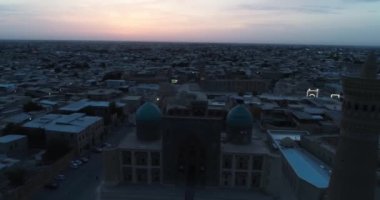 Şafakta eski şehrin ve ünlü anıt kompleksi iKalyan Poi Kalon Kompleksi ve Poi Kalon Minaret n Bukhara 'nın üzerinde bir dron uçar. Hava manzarası, Özbekistan.