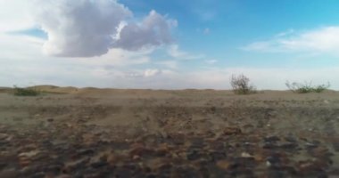 Bir İHA bulutlu bir günde çölün yüzeyinden havalanıyor.