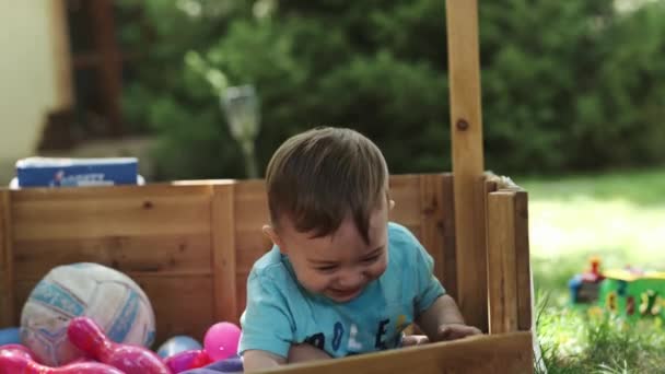 Маленький Европейский Мальчик Играет Красочными Гадостями Деревянном Доблести Улице Летом — стоковое видео