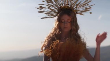 Sonbahar kıyafetli genç bir kadın model dağlarda günbatımına karşı poz veriyor. Yavaş Hareket, Kapat.