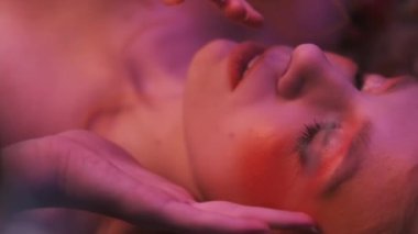 Dallardan, yapraklardan ve mısır başaklarından oluşan sonbahar kıyafeti içindeki genç bir kadının dağınık elmaların arasında çimlerin üzerinde uçarken çekilmiş yakın plan fotoğrafı. Yavaş Hareket.