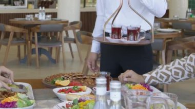 Bir garson restoranda içinde yemek olan bir masa servis eder. Kapat, Yavaş Hareket.