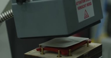 İşçinin elleri, parçayı fabrikadaki basının üzerine yerleştiriyor. Kapat, Yavaş Hareket.