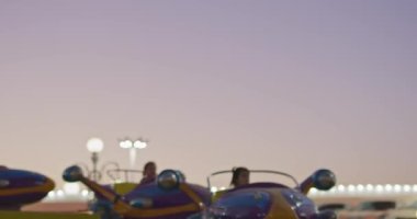Taşkent, Özbekistan - 84 2022: Çocuklar lunaparkta roket şeklinde bir atlıkarıncaya biniyorlar. Yavaş Hareket.