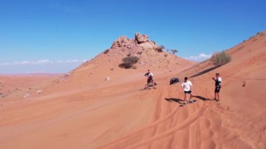 Çölün kum tepelerinde sörf yapan insanların insansız hava aracı görüntüsü. Hava Görünümü.