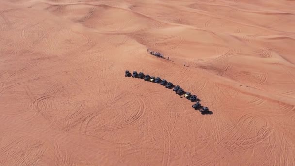 ドローンは砂漠の砂丘の上に立っているバギーのキャラバンを飛ぶ エアリアルビュー — ストック動画