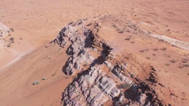 Çölün Kum Tepeleri Arasında Issız Bir Kayanın Üzerinden Bir Dron — Stok video