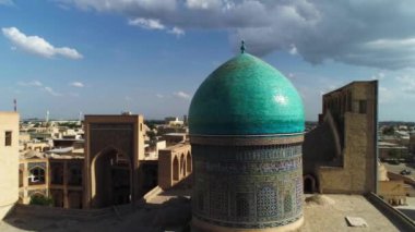 Drone, Poi-Kalon mimari kompleksinin ana kapısının üzerinden uçuyor. Eski Buhara, Özbekistan. Güneşli bulutlu bir gün. Hava Görünümü.