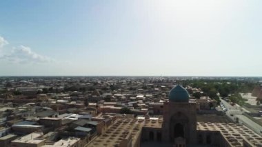 İnsansız hava aracı Poi-Kalon mimari kompleksinin ana kapısından iniyor. Eski Buhara, Özbekistan. Güneşli bulutlu bir gün. Hava Görünümü.