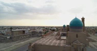 Bir İHA, Poi-Kalon mimari kompleksinin üzerinde uçuyor. Özbekistan 'ın eski Buhara kentindeki bir evin arka planında. Bulutlu bir gün. Hava Görünümü.