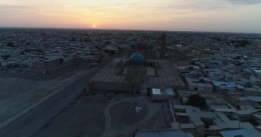 Özbekistan 'ın Buhara kentindeki eski evler arasında Poi-Kalon mimari kompleksinin üzerinde bir dron uçuyor. Erkenden bulutlu bir sabah. Hava Görünümü.