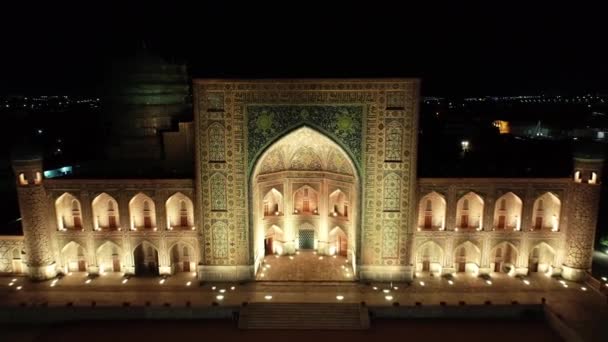 夜には 照明されたレグジスタンの複合体のドローンパノラマ サマルカンド ウズベキスタン 空中ビュー スローモーション — ストック動画