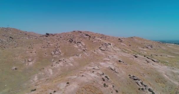 在一个无云的日子里 无人驾驶飞机在被群山环绕的岩石山上飞行 空中景观 慢动作 — 图库视频影像