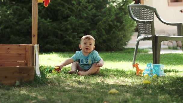 티셔츠를 소년과 바지가없는 놀이터에서 잔디에 맨발로 슬로우 화창한 — 비디오