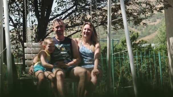 Famille Père Mère Fils Balançant Sur Une Balançoire Dans Parc — Video