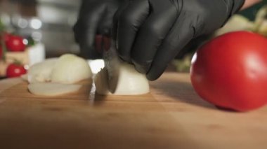 Şef soğanı kesme tahtasına bıçakla kesiyor. Yavaş Hareket.