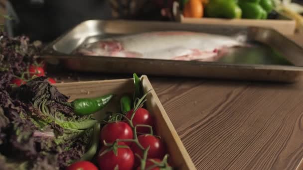 Kuchař Rukavicích Solí Ryby Kuchyňském Stole Mezi Bylinkami Rajčaty Zeleninou — Stock video