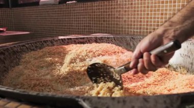 Şef büyük bir pilav kazanında slotlu kaşıkla pilav karıştırır. Yavaş Hareket, Kapat.
