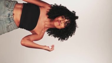 Siyah kıvırcık saçlı ve parlak makyajlı esmer bir kadının portresi. Gülümsüyor ve gülüyor. Kapat, Yavaş Hareket