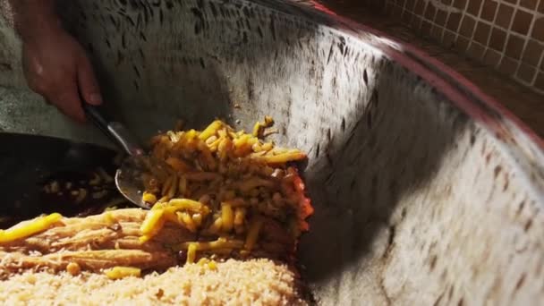 厨师在大锅里放胡萝卜和一个排开的勺子 用大锅里的米饭做小牛肉 慢动作 — 图库视频影像