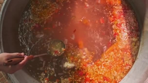 厨师把肉汤和蔬菜混合在一个大大锅里 用一个有槽的勺子 慢动作 — 图库视频影像
