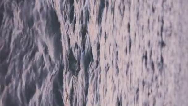 Eine Meereswelle Mit Schaumstoff Rollt Bei Sonnenuntergang Auf Einen Sandstrand — Stockvideo