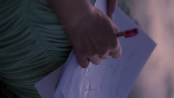 Una Joven Vestida Con Vestido Ligero Escribe Una Carta Hojas — Vídeo de stock