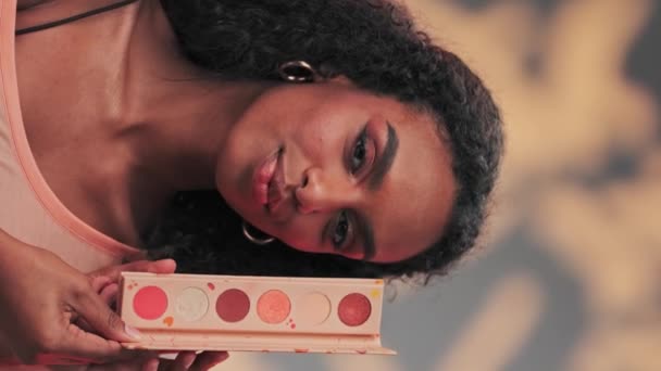 化粧品のセットを示す若い魅力的なモデル スローモーション スタジオショット — ストック動画