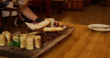 Bir garson restoranda içinde yemek olan bir masa servis eder. Kapat, Yavaş Hareket.