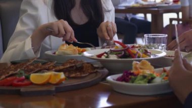 İnsanlar restoranda bir masaya oturur ve yemek yerler. Kapat, Yavaş Hareket.