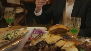 İnsanlar restoranda bir masaya oturur ve yemek yerler. Kapat, Yavaş Hareket.