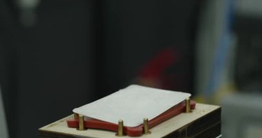 İşçinin elleri, parçayı fabrikadaki basının üzerine yerleştiriyor. Kapat, Yavaş Hareket.