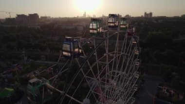 Bir dron lunaparkın üzerinde atlı karınca ve dönme dolap ile uçuyor. Hava görünümü.